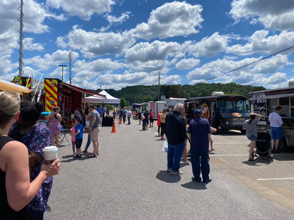 people buying food from food trucks on a sunny day