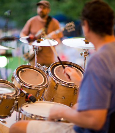 Image shows musicians in an outdoor setting