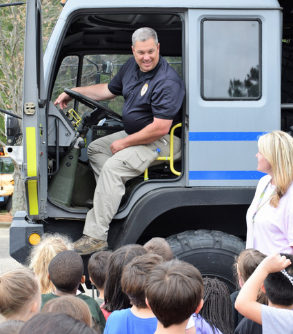 Police officer showing children police vehicle
